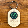 Drive Safe It's Not a Race laser-engraved maple keychain with black and green acrylic speedometer