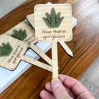 Hand holding Aloe There Gorgeous maple plant stake showing green acrylic aloe vera detail