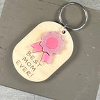 Best Mom Ever acrylic daisy keychain in pink on natural maple wood with key ring.