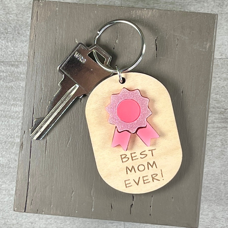 Best Mom Ever laser-cut maple keychain with pink flower and silver key ring.