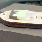 Side view of an oval wooden keychain with a layered lemon acrylic drip cake, highlighting the 3D effect of the design. 