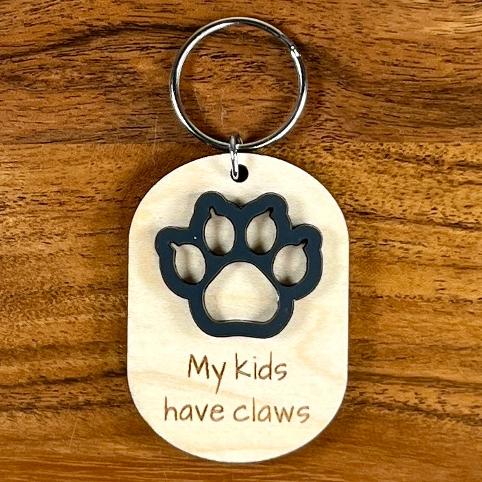 My Kids Have Claws laser-engraved maple wood keychain with black acrylic claw on wood background