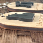 Life Is Better With Cats maple keychain on wood surface showing side view of dimensional layered black acrylic cat duo