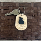 Life Is Better With Cats maple keychain with key attached on dark surface showing engraved text and black acrylic cat duo