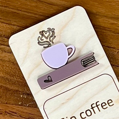 Close up of Sip Coffee Read Books Stay Cozy birch bookmark showing ash rose coffee cup on mauve acrylic book