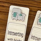 Close-up of sage acrylic cozy chair and mug on Introverting with Books birch bookmark