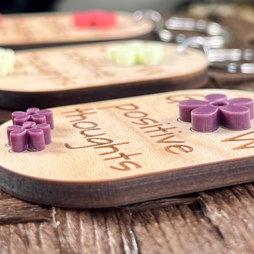 Close-up of Grow Positive Thoughts maple keychain showing layered purple lemon and watermelon acrylic daisy detail and engraved text
