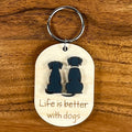 Life Is Better With Dogs laser-engraved maple wood keychain with black acrylic dog silhouettes on wood background