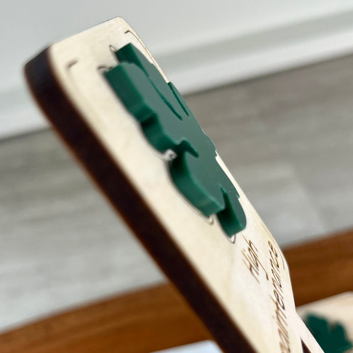 Side view of High Maintenance plant stake showing layered maple wood and forest green acrylic depth