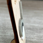Close-up side view of a light wood magnet with a layered gray and white acrylic golf club and ball layer, photographed against a blurred gray surface and designed to highlight the 3D effect of the acrylic.