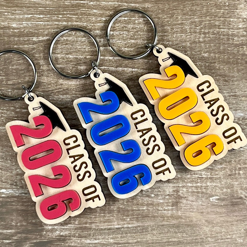 Class of 2026 laser-engraved maple graduation keychains with acrylic grad cap and watermelon, blue and mango numeral variants