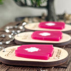 Proudly Canadian maple keychains displayed on wood surface showing engraved text and red acrylic hockey jersey
