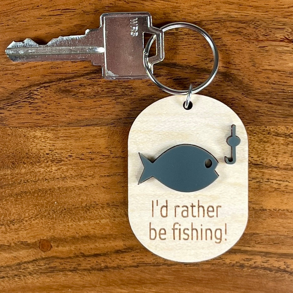 I'd Rather Be Fishing maple keychain with key attached showing blue acrylic fish and hook on wood background