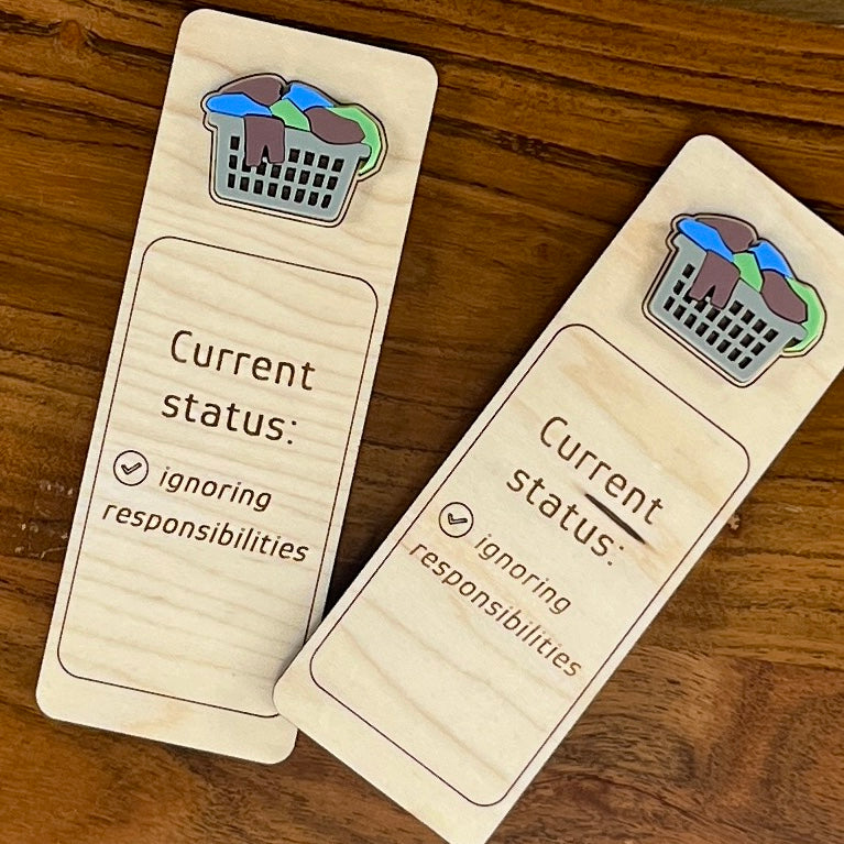 Current Status Ignoring Responsibilities birch wood bookmark with overflowing acrylic laundry basket