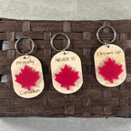 Collection of Canadian pride maple keychains showing full family of sayings with red acrylic maple leaf detail