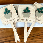 Three Mint to Be maple wood plant stakes with dark green acrylic mint leaves and taupe pot