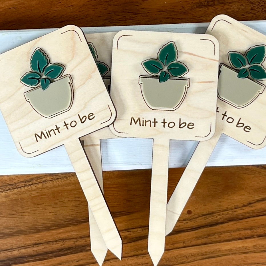 Three Mint to Be maple wood plant stakes with dark green acrylic mint leaves and taupe pot