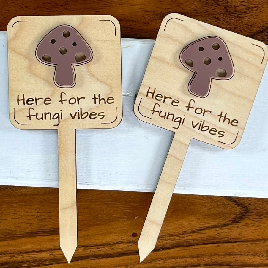 Two Here for the Fungi Vibes maple wood plant stakes with mauve acrylic mushroom accent side by side