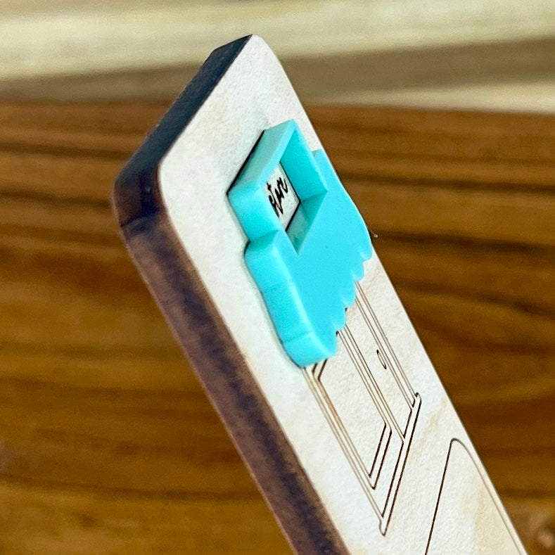 Side view of I Brake for Bookstores birch bookmark showing dimensional acrylic layers