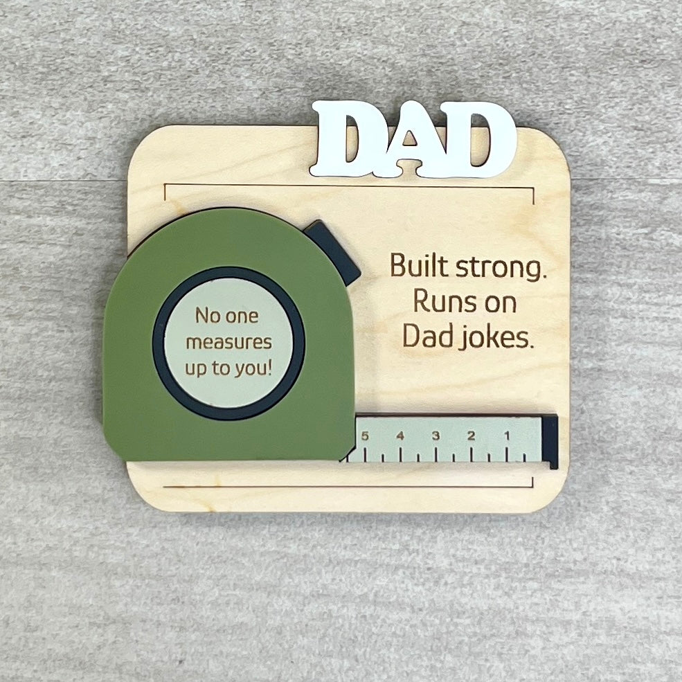 Flat lay of handcrafted tape measure fridge magnet made from natural maple with matte acrylic
