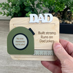 Handcrafted tape measure magnet held in hand showing personalized name and engraved message