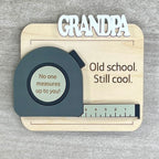 Flat lay of handcrafted tape measure fridge magnet - Old School Still Cool on natural maple