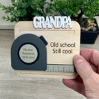 Handcrafted tape measure magnet held in hand showing personalized name and engraved message