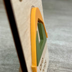 Side view of a maple magnet highlighting  the 3D layered acrylic tent design set against a blurred gray background.