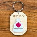 Never 51 laser-engraved maple wood keychain with white acrylic toque and red maple leaf on wood background
