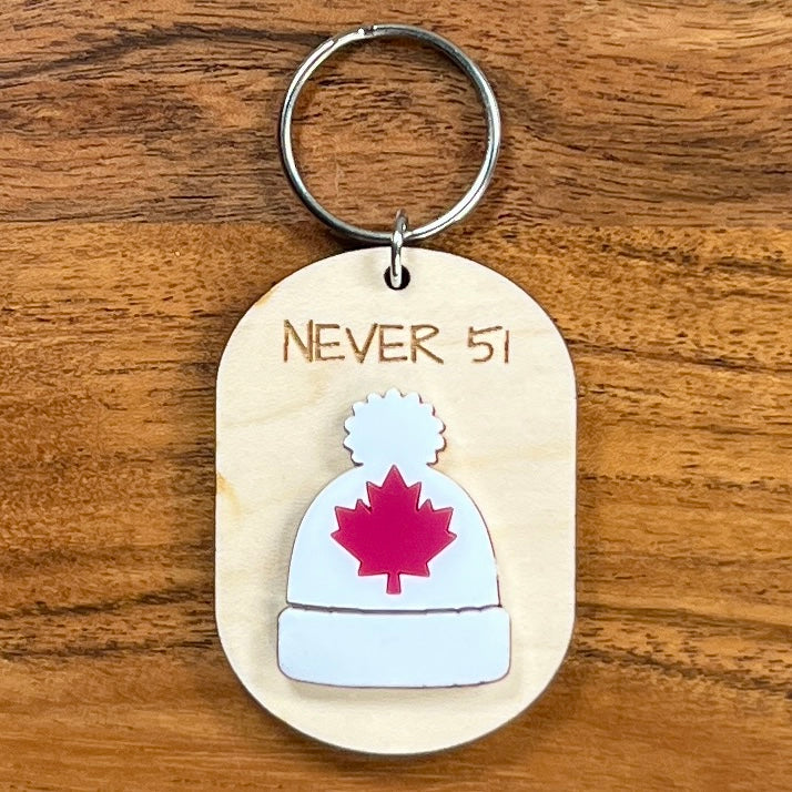 Never 51 laser-engraved maple wood keychain with white acrylic toque and red maple leaf on wood background