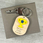 Best Dad Ever wood keychain with key ring on neutral background