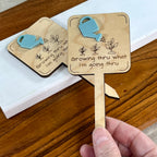 Hand holding Growing Thru What I'm Going Thru laser-cut maple wood and acrylic plant stake