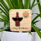 Day Drinker laser-cut maple wood and acrylic plant stake displayed in a white potted plant